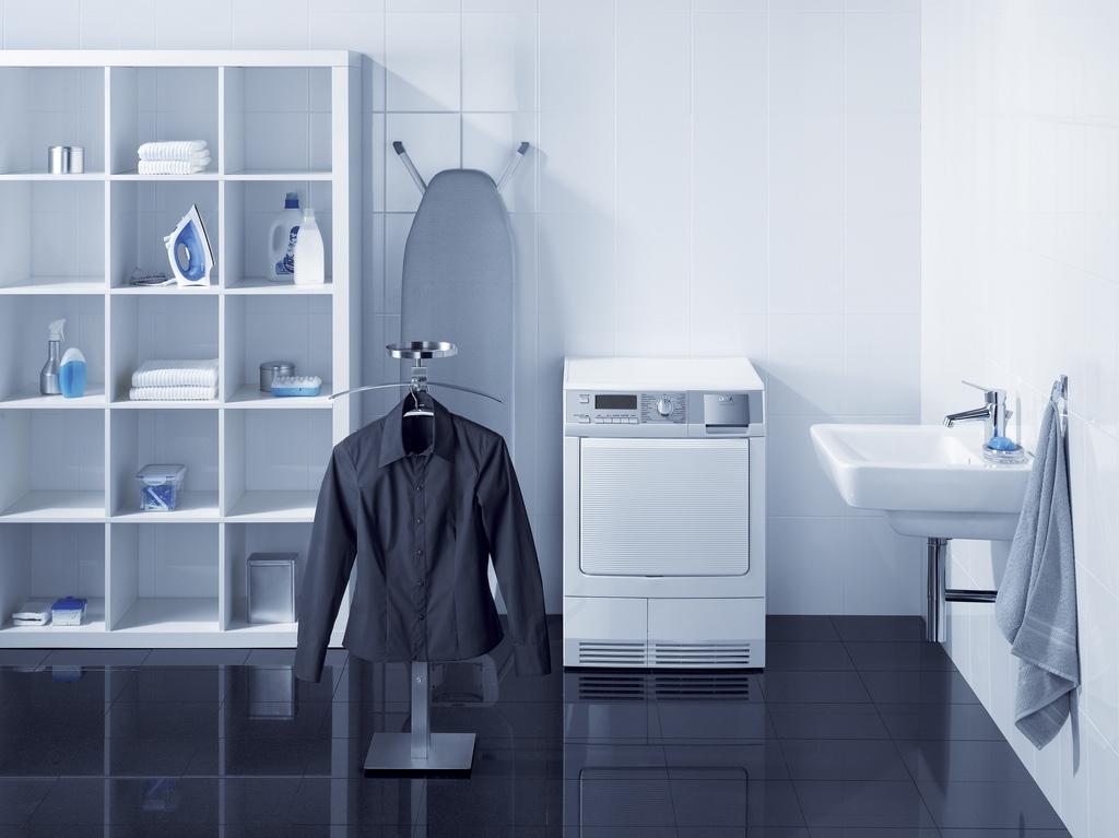 highlight of this laundry room is enclosed in a cabinet with many storage holes