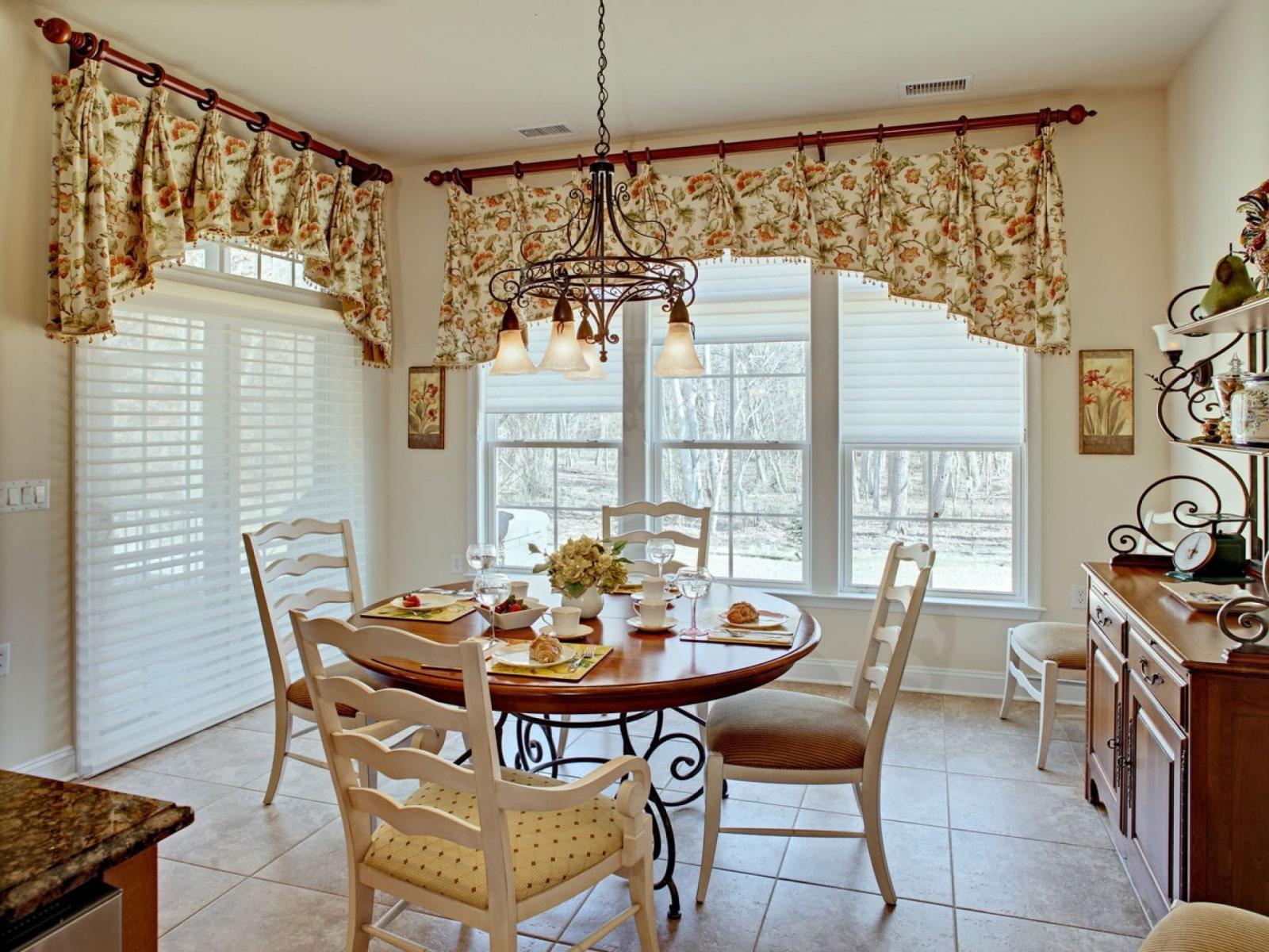 country-style kitchen-dining room with a wrought-iron pendant chandelier above the dining area.