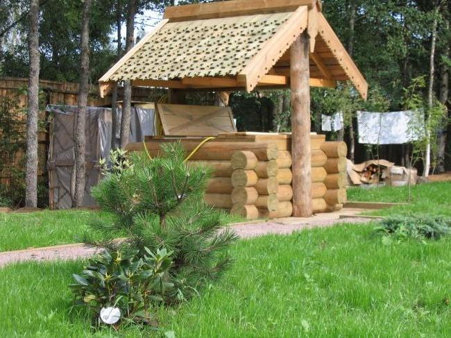 Beautiful wooden small house for a well with carved elements