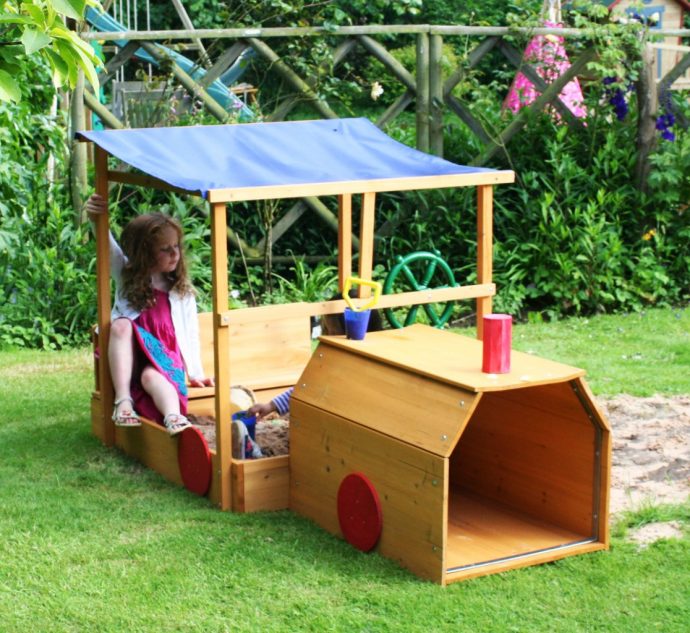 Simple square sandbox of several planks with sun umbrella