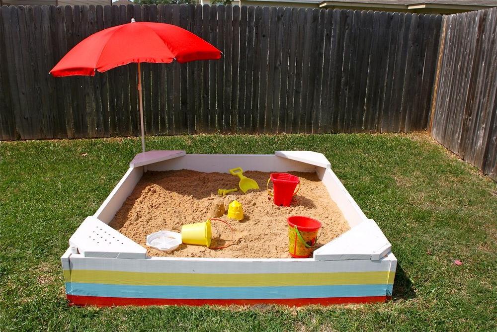 Simple square sandbox with corner seats and a sun umbrella