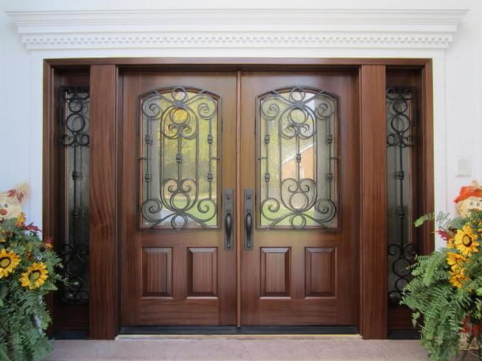 wooden doors with laconic carvings in a classic style visually highlight the ornate pattern on the glass